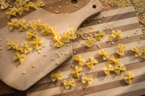 Diferentes tipos de pasta Cellentani, Tortiglioni, Farfalle, espaguetis se utilizan a menudo en la cocina para cocinar. - Foto, Imagen