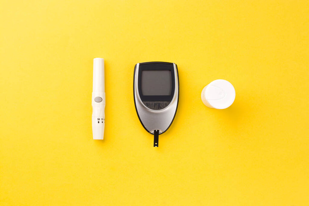 Krevní glukózoměr, hladina cukru v krvi se měří na prstu na bílém pozadí. - Fotografie, Obrázek