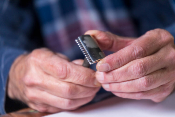 An old man is holding a razor that belonged to his father - Photo, image