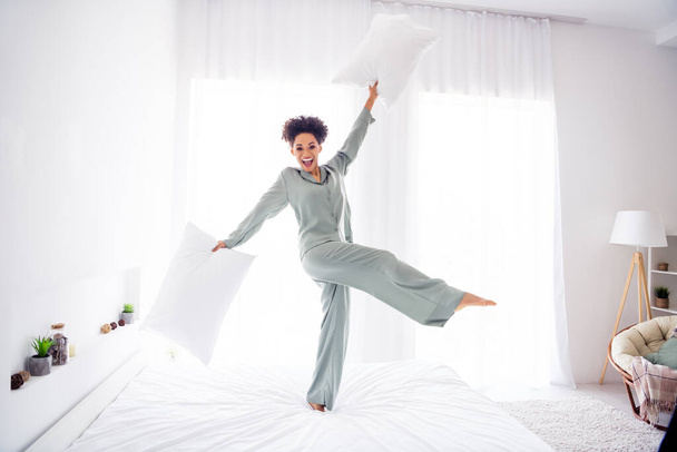 Full length body size view of attractive cheerful girl dancing on bed having fun at light white home indoors - Valokuva, kuva