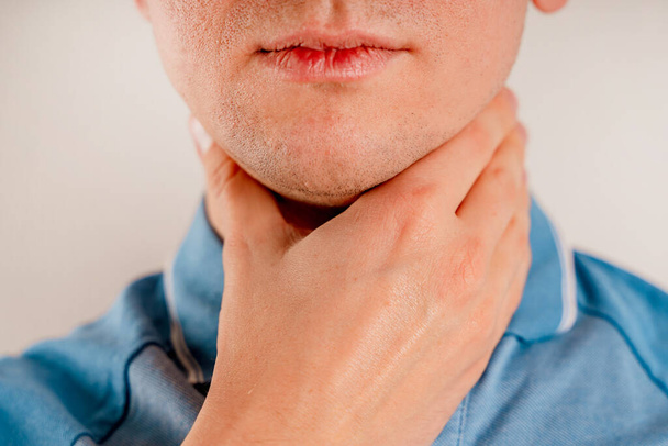 Un homme vérifie les ganglions lymphatiques sur son cou. - Photo, image