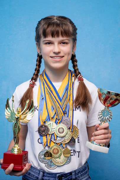 ragazza con premi, molte medaglie su un bambino, vincitore, ritratto - Foto, immagini