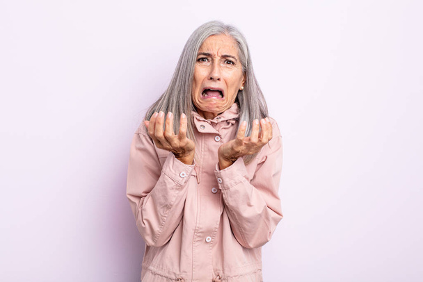 middle age gray hair woman looking desperate and frustrated, stressed, unhappy and annoyed, shouting and screaming - 写真・画像