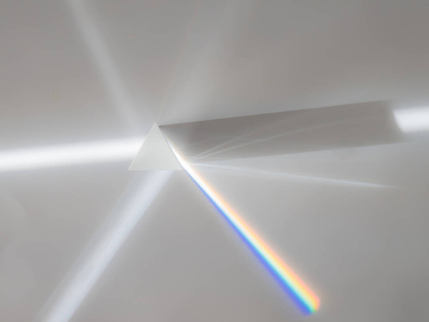 A napsugár szétszóródása (fehér fény) egy fénytörést, visszaverődést és a fény oszlását eredményező prizmán keresztül a szivárvány színeiben - Fotó, kép
