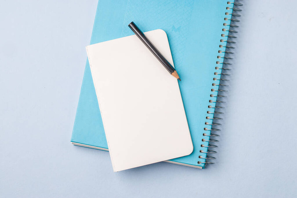 Prázdný zápisník připravený k použití na modrém stole, pohled shora, plochý. - Fotografie, Obrázek