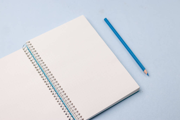 Leeg notitieboekje klaar voor mockup op blauwe tafel, bovenaanzicht, flatlay. - Foto, afbeelding