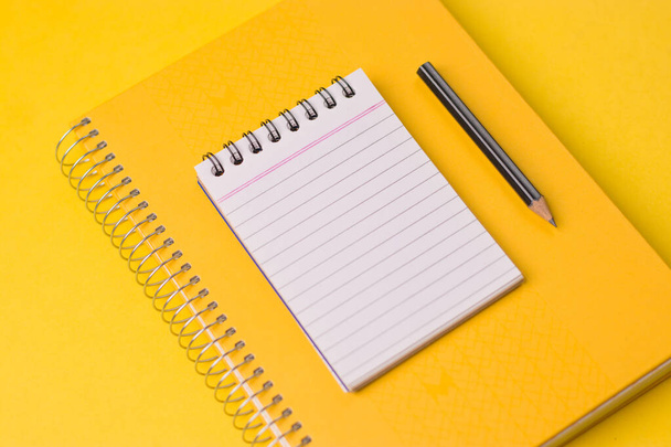 Empty notebook ready for mockup on yellow table, top view, flatlay. - Foto, Imagen