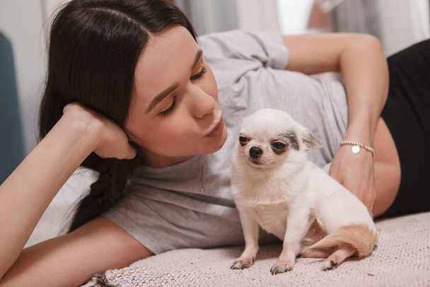 Close up of a woman kissing her funny small chihuahua dog - Photo, Image