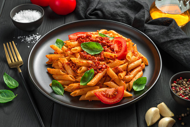バジルと新鮮なトマトとボロネーゼパスタを閉じます。伝統的なイタリア料理. - 写真・画像