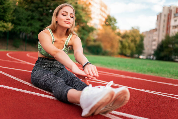 Positive sports girl doing stretching before running - Foto, immagini