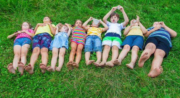 Children's feet lie on the grass. Selective focus. Kid. - Foto, imagen