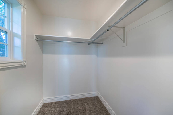 Μικρή άδεια βόλτα στην ντουλάπα με λευκό εσωτερικό και παράθυρο - Φωτογραφία, εικόνα
