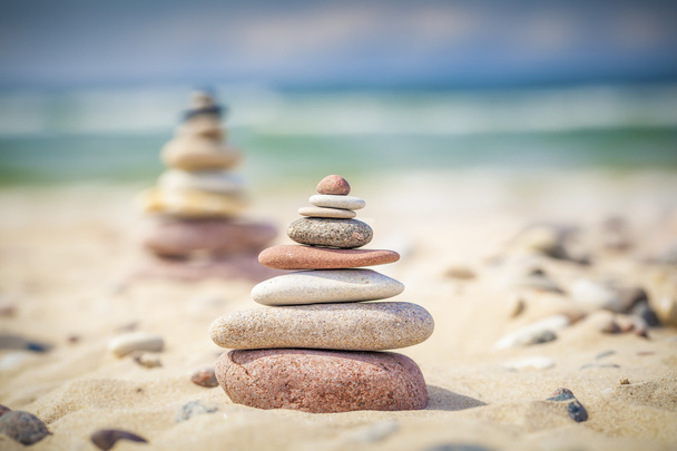 Pierres équilibrées empilées sur un sable près de la mer
 - Photo, image