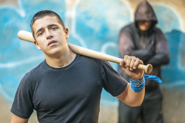 Adolescente agressivo com um taco de beisebol no fundo do edifício
 - Foto, Imagem