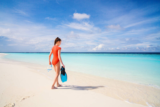 Вид ззаду дівчинка-підліток з обладнанням для підводного плавання на пляжі під час літніх канікул
 - Фото, зображення