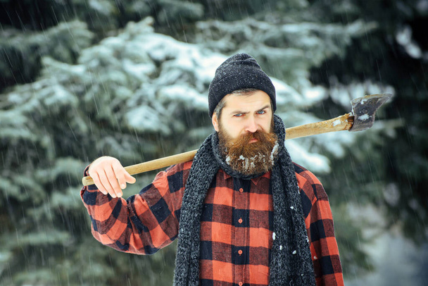 Serious man lumberjack with axe outdoor in winter - Zdjęcie, obraz