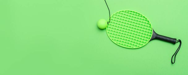 Πράσινη ρακέτα και μπάλα στο πράσινο φόντο. Οριζόντια αφίσα θέματος αθλητισμού, ευχετήριες κάρτες, κεφαλίδες, ιστοσελίδα και εφαρμογή - Φωτογραφία, εικόνα