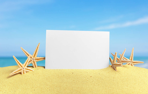 Seashells with blank card on sand beach - Foto, imagen