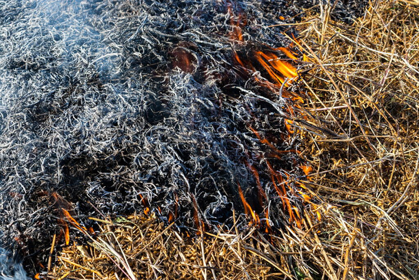 Hintergrund des Feuers steigt aus brennendem Stroh in schwarze Asche und Rauch auf. - Foto, Bild