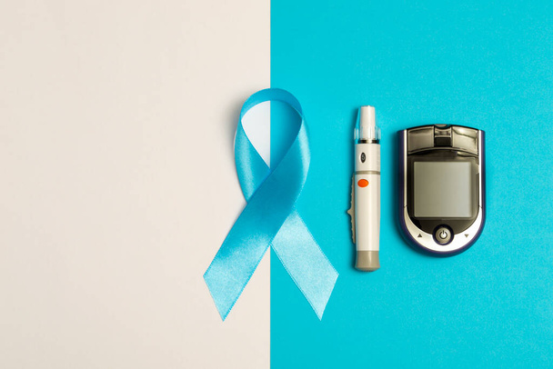 Παγκόσμια Ημέρα Διαβήτη. Γλυκόμετρο με επίπεδο και μπλε ταινία σε λευκό και μπλε φόντο Ιατρικό πρότυπο υγειονομικής περίθαλψης. Αντιγραφή χώρου - Φωτογραφία, εικόνα