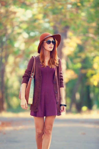 krásná rusovláska dívka s taškou v parku公園でバッグを持つ美しい赤毛の女の子. - 写真・画像