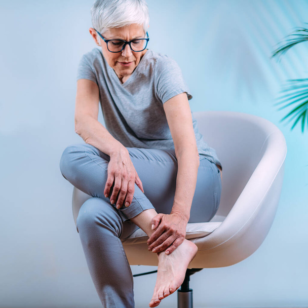 Senior woman with ankle joint pain. - Foto, Imagen