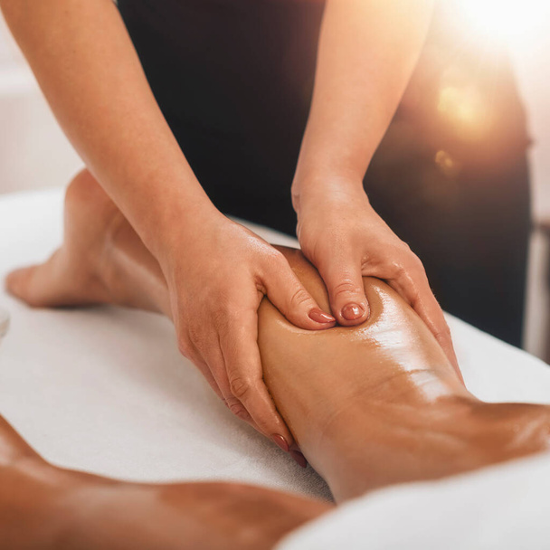 Anti-Cellulite Massage. Masseurin massiert Wadenbereich eines weiblichen Beines, um Cellulite zu reduzieren  - Foto, Bild