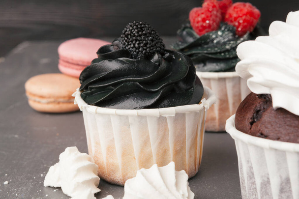 leckere Himbeer-Cupcakes auf dunklem Hintergrund - handgemachtes süßes Dessert - Foto, Bild