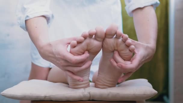 Mãos femininas cócegas, massagem nas pernas nuas, pés de uma criança. 4K. Fechar - Filmagem, Vídeo