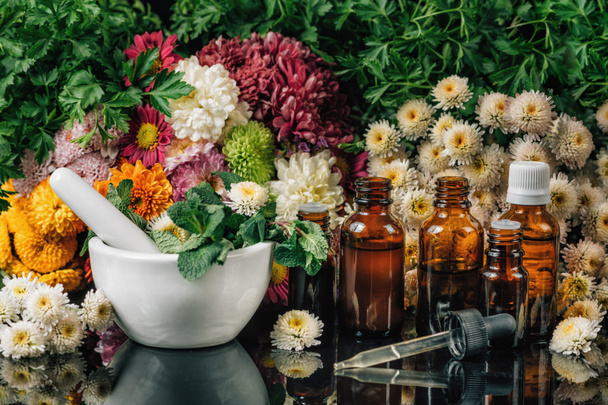 Bach virág jogorvoslatok - Alternatív gyógynövény. Üvegek, virágok, habarcs és mozsártörő tele friss mentával  - Fotó, kép