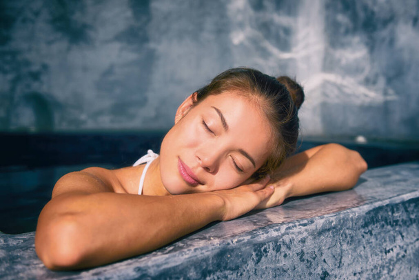 Wellness pool spa pampering Asian woman relaxing in luxury resort. Hot tub jacuzzi at hotel holiday weekend getaway - Fotó, kép