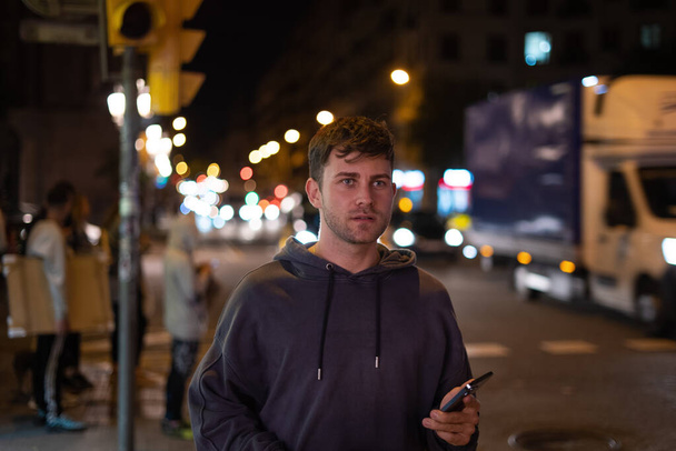 Férfi okostelefonnal az utcán éjszaka - Fotó, kép
