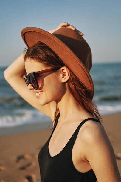 mujer alegre en gafas de sol arena costa paisaje sol - Foto, Imagen