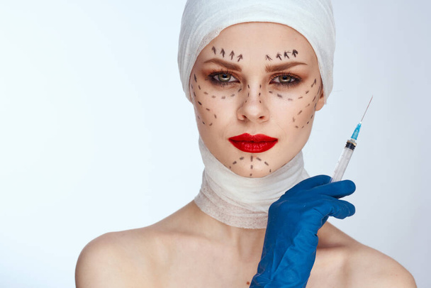 beautiful woman in blue gloves syringe in hands contour on the face lifting studio lifestyle - Fotó, kép