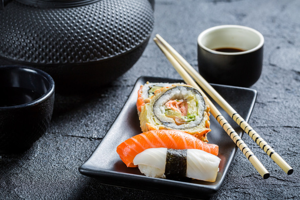 Fresh sushi served in a black ceramic - Photo, image