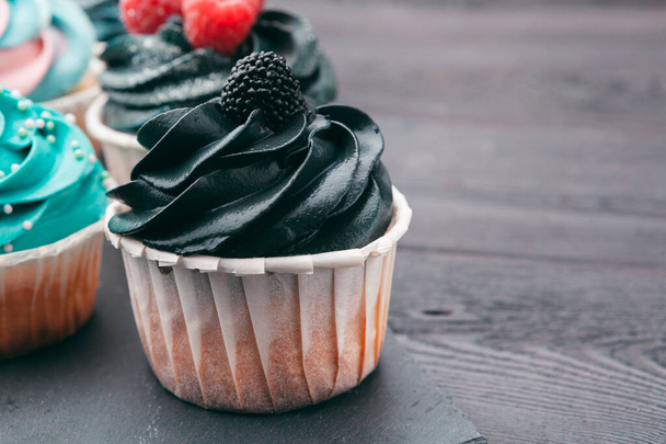 Set of different delicious cupcakes on dark - Photo, image