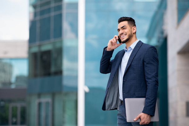 Happy middle eastern young entrepreneur having phone conversation - Photo, Image