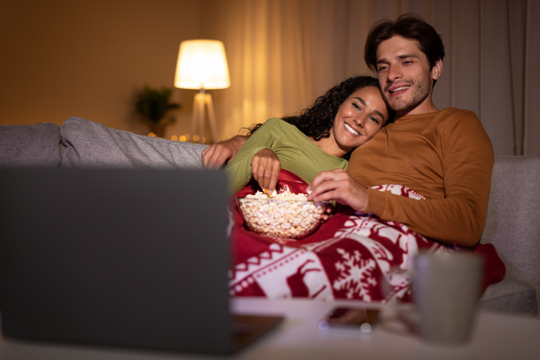 Pareja disfrutando de la Nochebuena viendo películas de Navidad en línea en casa - Foto, Imagen