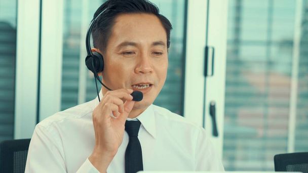 Biznesmen noszący słuchawki pracujący aktywnie w biurze - Zdjęcie, obraz