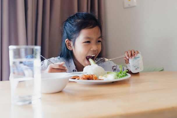 Sick asian child girl eating healthy food for lunch by herself while stay in private patient rooms in the hospital. Healthcare and lifestyle concept. - Valokuva, kuva
