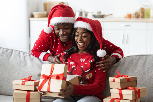 Excited african american family opening Christmas gifts together - Foto, Imagem