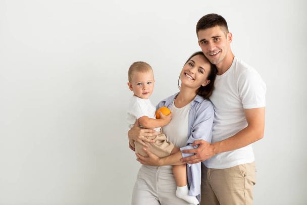 Happy Young Parents Holding Their Cute Toddler Son And Smiling At Camera - Foto, afbeelding
