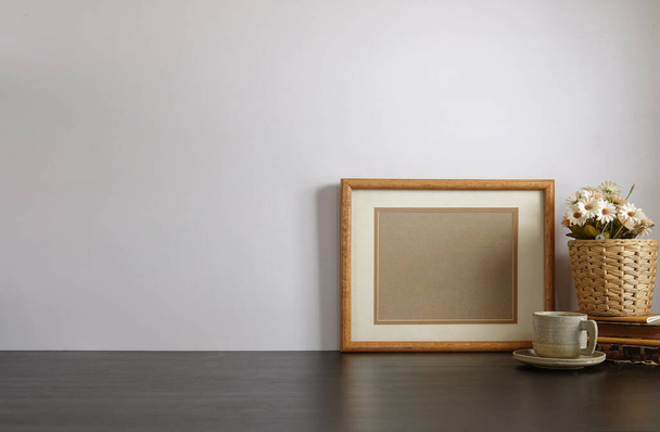 Elegante spazio di lavoro con pianta d'appartamento, macchina fotografica e tazza di caffè su tavolo bianco con muro di mattoni. - Foto, immagini
