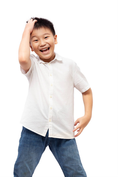Ευτυχισμένο παιδί που διασκεδάζει φορώντας πουκάμισο και τζιν απομονωμένο σε λευκό φόντο - Φωτογραφία, εικόνα