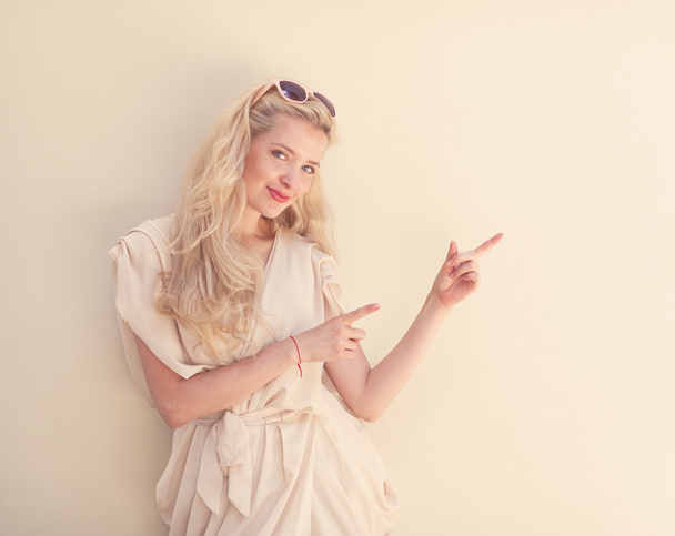 Summer portrait of young beautiful blond woman in white dress posing near the wall and have fun. Toned in warm colors - Foto, Imagem