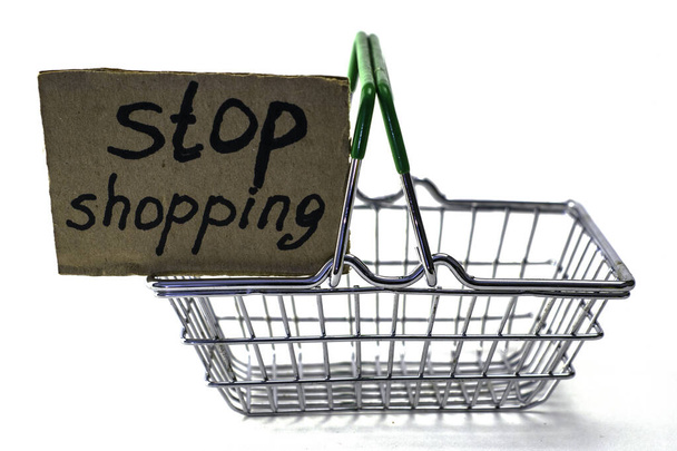 il concetto di rifiuto di acquistare un consumo ragionevole è un carrello con l'iscrizione stop shopping su sfondo bianco. Foto di alta qualità - Foto, immagini