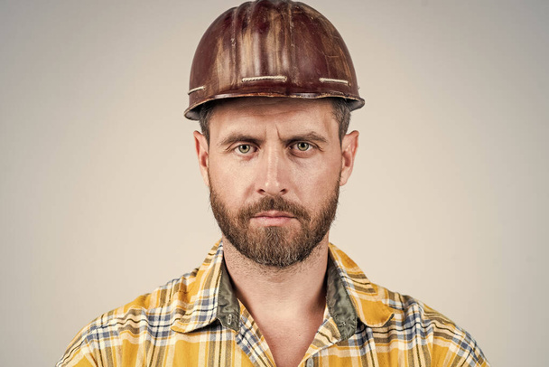 man architect with serious look. guy wear worker uniform. handsome builder in helmet. mature man wear checkered shirt. professional constructor or mechanic. builder engineer - Photo, Image