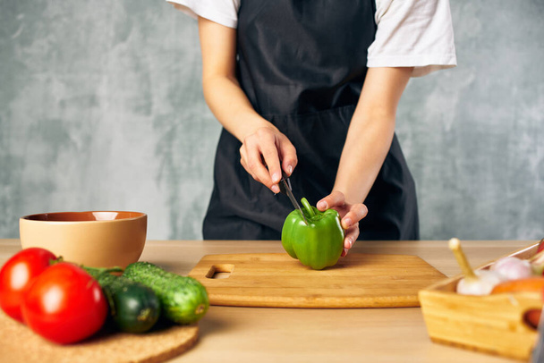 Donna in grembiule nero Cucina sana alimentazione insalata dieta - Foto, immagini