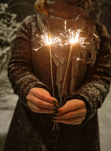 Девушка гуляет в Рождественском парке с праздничными огнями по вечерам. Чувствую себя счастливым в большом городе. - Фото, изображение