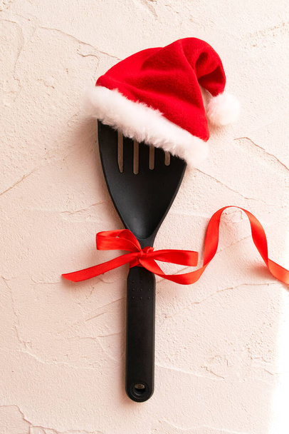 Christmas and new year composition with kitchen tools and Santa hat on grey conctere background. Xmas cooking concept. Top view with copy space - Foto, imagen